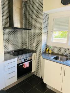 uma cozinha com um fogão preto e um lavatório em Lovely Apartment to feel Lisbon em Lisboa