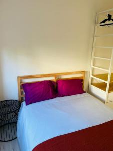 a bedroom with a large bed with purple pillows at Lovely Apartment to feel Lisbon in Lisbon