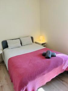 a bedroom with a large bed with a pink blanket at Lovely Apartment to feel Lisbon in Lisbon