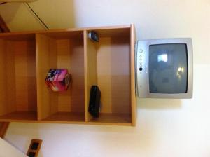 a small tv sitting on a shelf next to at Gästehaus Waldmohr in Waldmohr