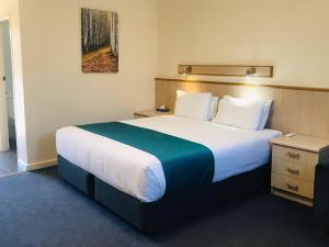 a hotel room with a bed and a dresser at Comfort Inn Glenelg in Adelaide