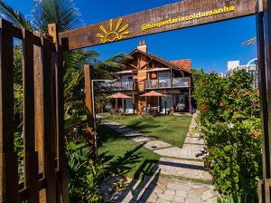 a wooden gate to a house with a resort at Hospedaria Sol da Manhã in Bombinhas