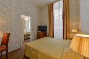 a hotel room with a bed and a television at Albergo Alla Posta in Trieste