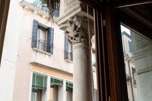 a pole in front of a building with a window at Cà Paola Cozy Venice Apartment in Venice