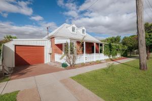 a white house with a red garage at Marleys Loft in Mudgee