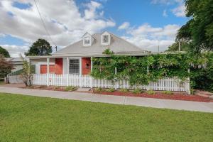 a white house with a white picket fence at Marleys Loft in Mudgee