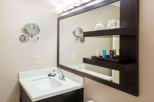 a bathroom with two sinks and a mirror at Sonesta Atlanta Airport North in Atlanta