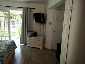 a bedroom with a bed and a tv on the wall at Mystic Ridge Apt 26F in Ocho Rios