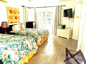a hotel room with two beds and a television at Mystic Ridge Apt 26F in Ocho Rios