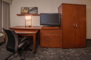 a hotel room with a desk with a television and a chair at Sonesta Select Arlington Rosslyn in Arlington