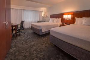 a hotel room with two beds and a desk at Sonesta Select Arlington Rosslyn in Arlington