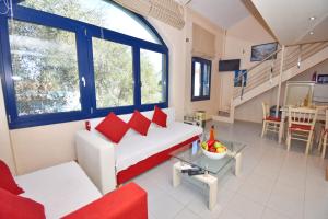 - un salon avec un canapé blanc et des oreillers rouges dans l'établissement Gouvia - Luxury Suite, à Gouviá