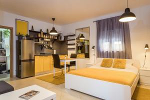 Cet appartement comprend une chambre avec un lit blanc et une cuisine. dans l'établissement Studio Vita Julija, à Pula