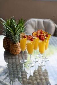 a group of four glasses of orange juice on a table at Pina Mimosa - Airlie Beach in Airlie Beach