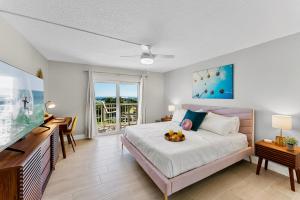 a bedroom with a large bed and a television at Cocoa Beach Towers in Cocoa Beach