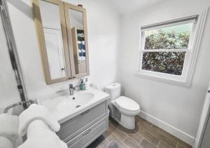 ein Badezimmer mit Waschbecken und Toilette und einem Fenster in der Unterkunft North Park Bungalow Resort in San Diego + 28 Fotos