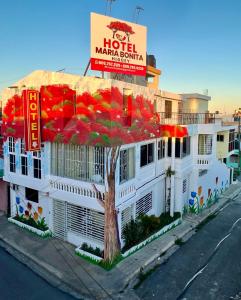 a hotel with a sign on the side of a building at Hotel María Bonita Higüey, Apartments in Higuey