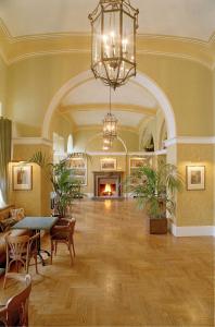 a large lobby with a fireplace and a chandelier at Albergo Alla Posta in Trieste