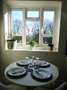 een tafel met borden en keukengerei voor een raam bij LUXE HILL GETAWAY in Londen