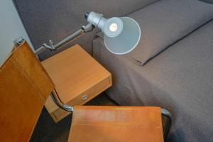 a desk with a lamp and a chair next to a bed at Albergo Alla Posta in Trieste