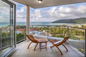 Un balcón con sillas y vistas al océano. en The Top Floor Luxury accomodation for 2 Spa Bath, en Airlie Beach