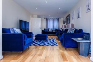 a living room with blue couches and a table at Lux Ulverston in Broughton