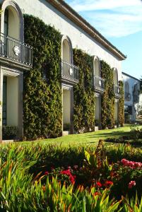 un bâtiment recouvert de lierre et de fleurs dans une cour dans l'établissement Hotel & Spa Hacienda Baruk, à Zacatecas