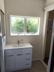 a bathroom with a sink and a window at Astral Motel in Whanganui