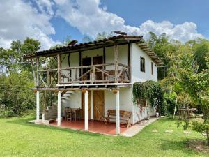 a small white house with a porch at Posada Chaska in San Agustín