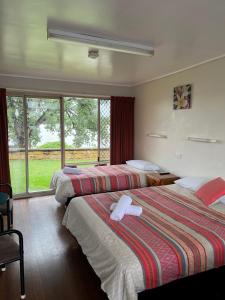 a hotel room with two beds and a window at Crown Hotel Motel in Grafton