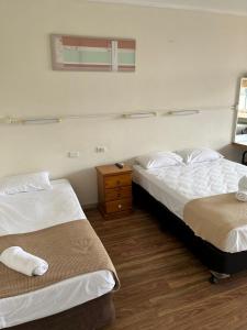 a hotel room with two beds and a dresser at Crown Hotel Motel in Grafton