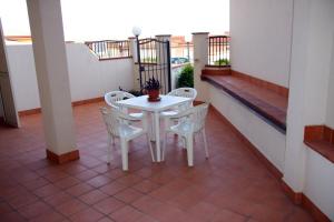 un tavolo bianco e sedie sul balcone di Residence Gioiosa Marea a Gioiosa Marea