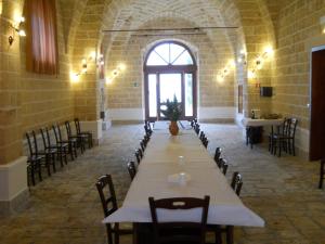 ein großer Raum mit einem langen Tisch und Stühlen in der Unterkunft Agriturismo Tenuta Perruzzi in Leverano