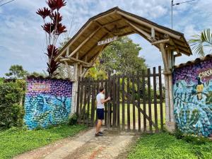 a man standing in front of a fence with graffiti at Posada Chaska in San Agustín