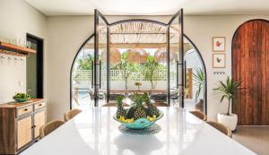 a dining room with a table with a bowl of fruit on it at Casa 88 Berawa in Canggu