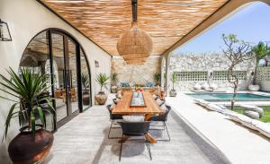 a patio with a table and chairs and a pool at Casa 88 Berawa in Canggu