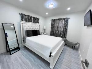 a bedroom with a large white bed and a mirror at Stylish 2 Bedrooms Apartment by Miami International Airport in Miami