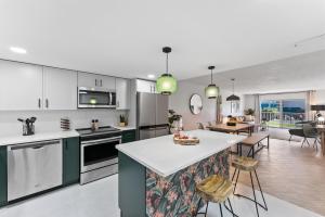 a kitchen with green cabinets and a dining room at Cocoa Beach Towers in Cocoa Beach