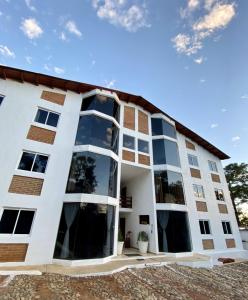 un gran edificio blanco con grandes ventanas en Herradura VIP Inn, en Mazamitla