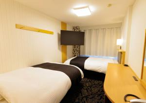 Postel nebo postele na pokoji v ubytování APA Hotel Kokuraeki Shinkansenguchi