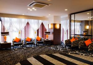 um átrio de hotel com sofás, mesas e janelas em APA Hotel Kokuraeki Shinkansenguchi em Kitakyushu