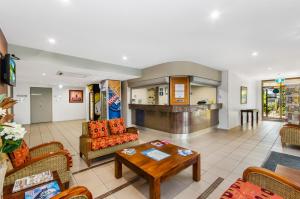 ein Wohnzimmer mit einem Sofa und einem Tisch in der Unterkunft Waters Edge The Strand in Townsville