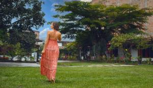 Una mujer con un vestido rojo de pie en la hierba en Country Club Eco Casajardin en Moyobamba