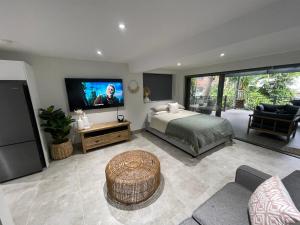 a bedroom with a bed and a flat screen tv at Quiet private getaway, private gym walk 2 beach in Terrigal