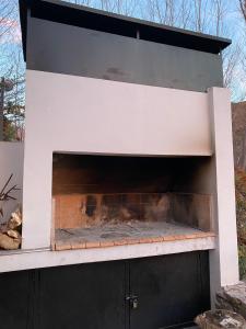 a black and white oven with a fire in it at Casa El Ciprés in Potrerillos