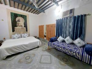 een slaapkamer met twee bedden en een standbeeld erin bij Virasat E Punjab -Farmstay Amritsar in Nūruddīn