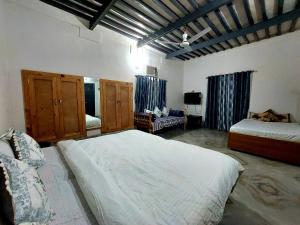 a bedroom with two beds and a tv in it at Virasat E Punjab -Farmstay Amritsar in Nūruddīn