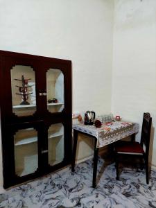 Virasat E Punjab -Farmstay Amritsar في Nūruddīn: غرفة مع طاولة وخزانة وطاولة وكرسي