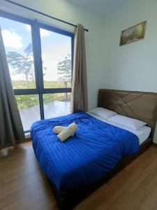a bed with a blue comforter with a towel on it at The clio 2 residences, beside conezion, beside ioi city mall, opposite serdang hospital, beside uniteen and UPM, Putrajaya in Putrajaya