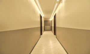 a hallway with two doors and a tile floor at Treebo Sriz Cozy Seethamadhara in Visakhapatnam